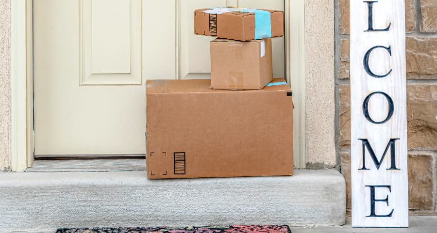 Packages on the doorstep of a home with a welcome sign in Auburn